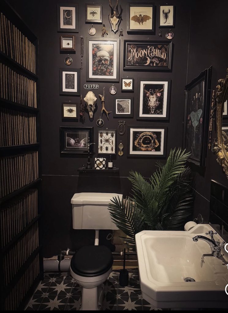 Vintage wall art in dark academia bathroom 