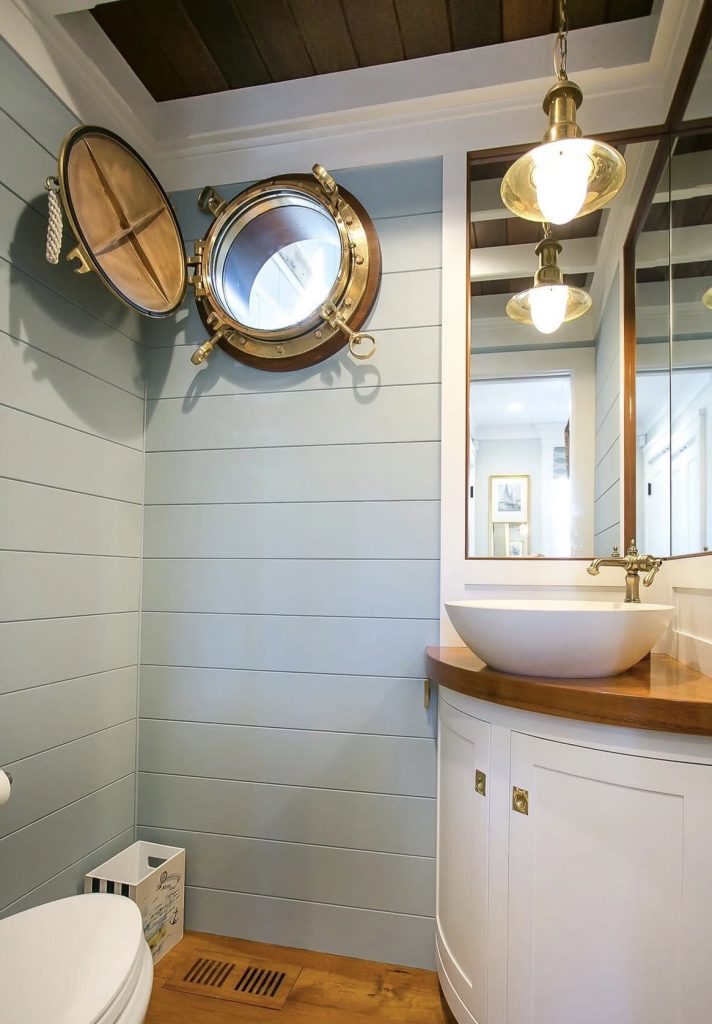 Porthole style mirror in a nautical bathroom 