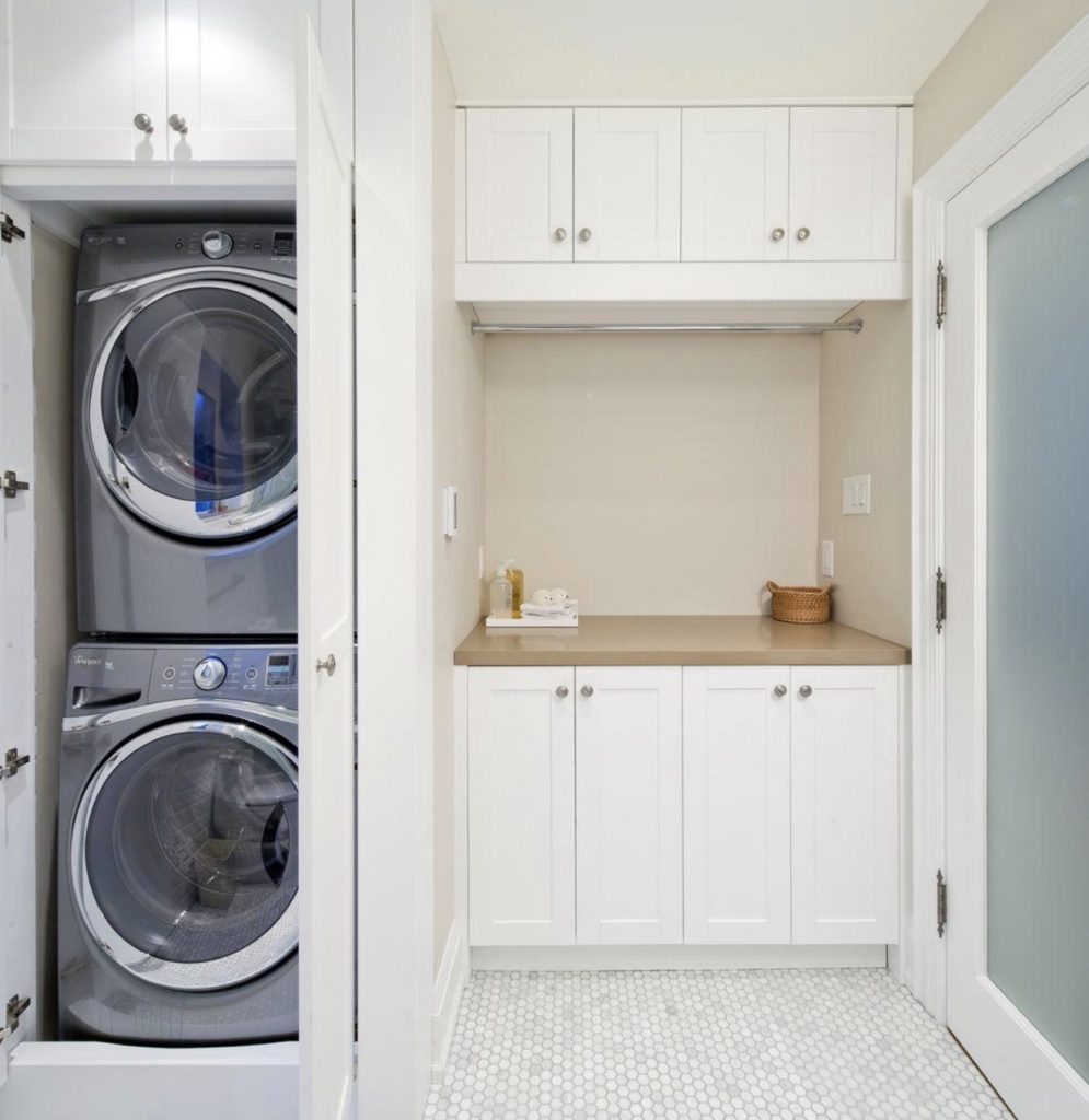 Built-In Stacked Laundry Room With White Cabinets